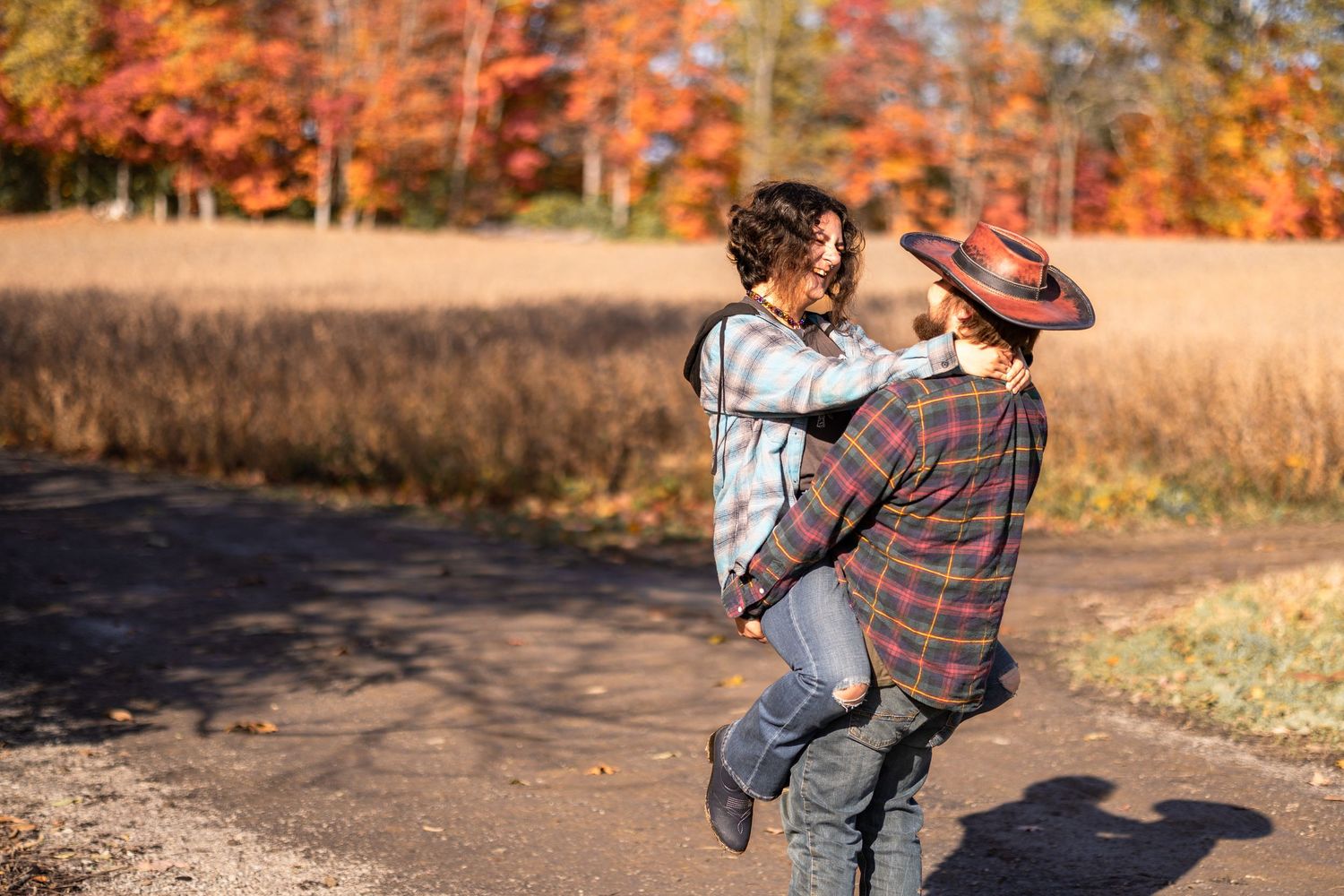 Fall Engagement session on scenic autumn path surrounded by colorful fall foliage.