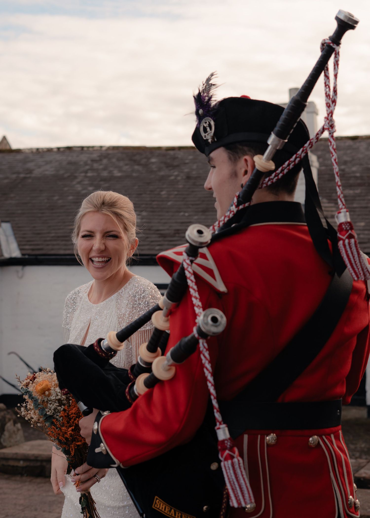 Bride with a traditional Scottish bagpiper at Gretna Green, photographed by a Scotland wedding and elopement photographer.