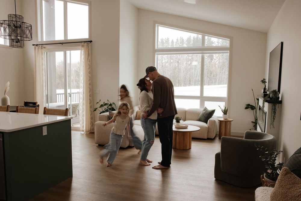 Family enjoying a bright modern living room with large windows, open floor plan, and contemporary decor.