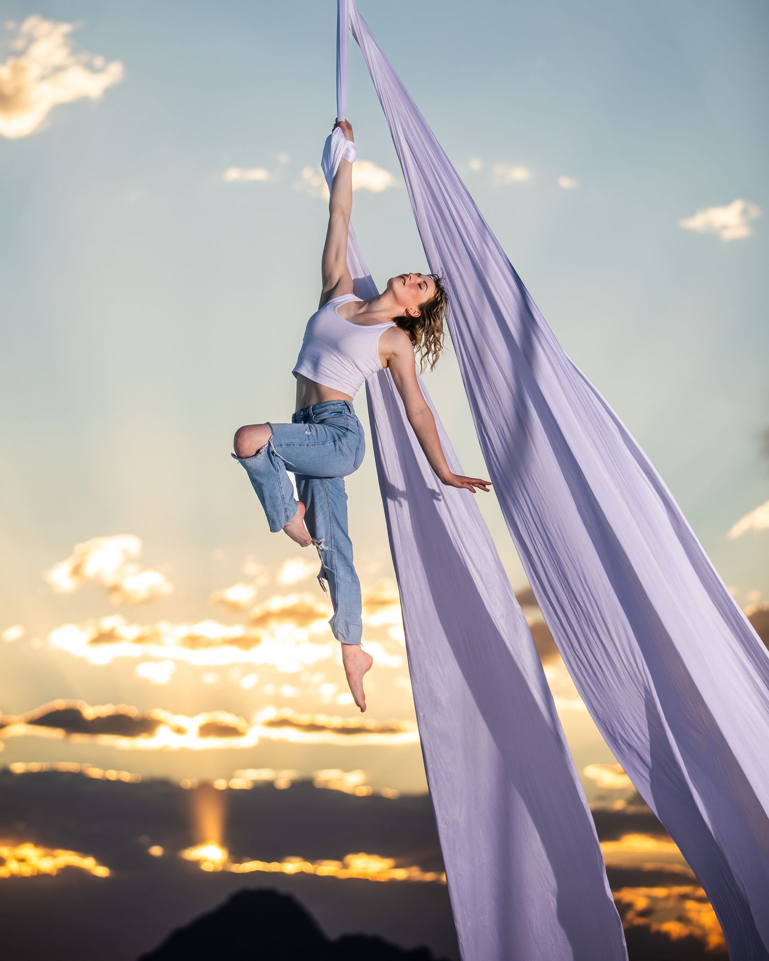 Studio aerialist photo on white backdrop; professional aerial arts photography and commercial aerialist photoshoot capturing portraits.