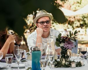 Wedding reception table settings with wine glasses, floral centerpieces and elegant place settings.