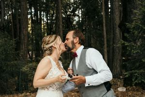 A couple shares a sweet moment together in a serene forest setting at sunset.