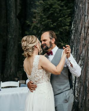 Couple sharing their first dance at outdoor forest wedding reception.