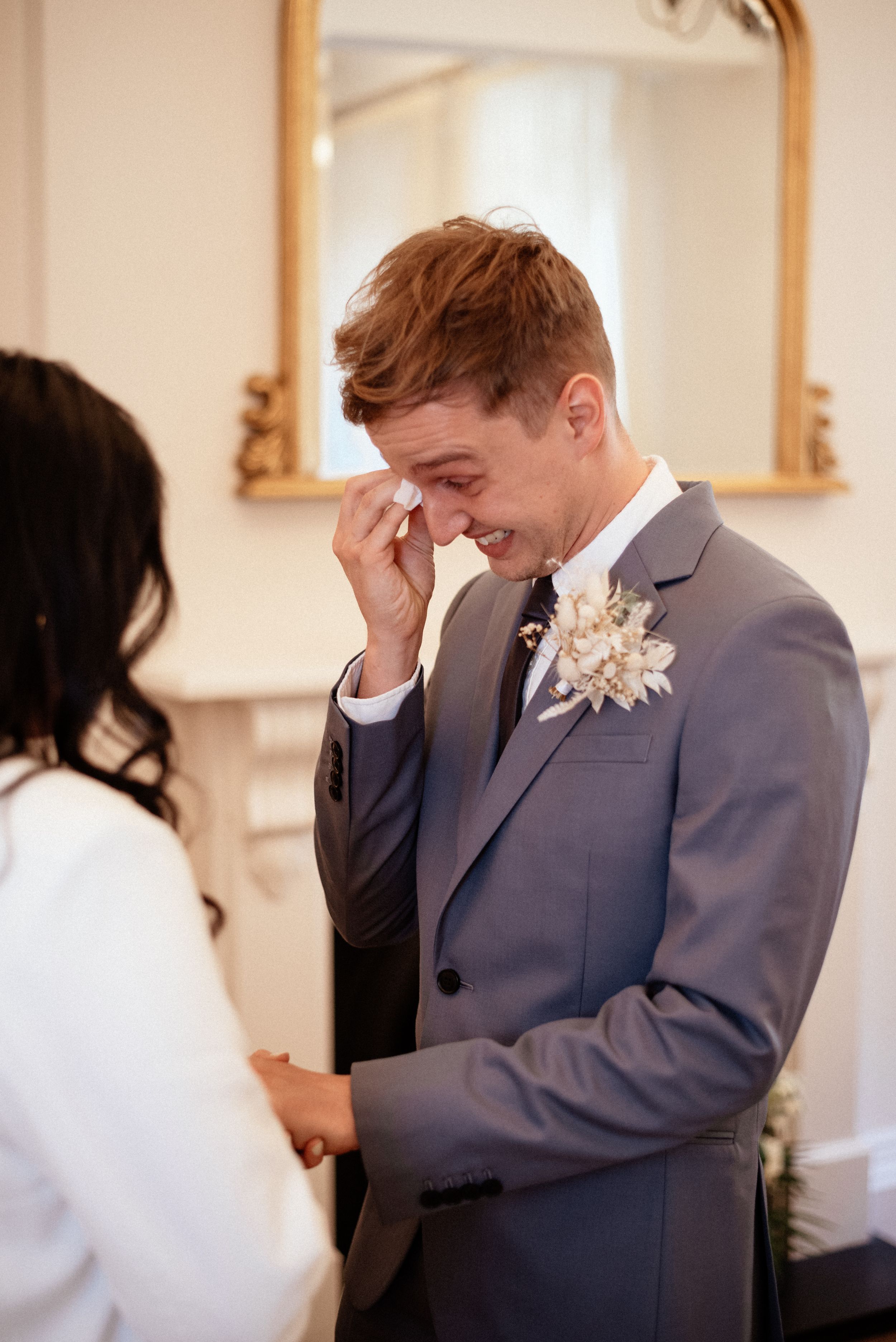 Emotional wedding ceremony reactions in a bright indoor venue.