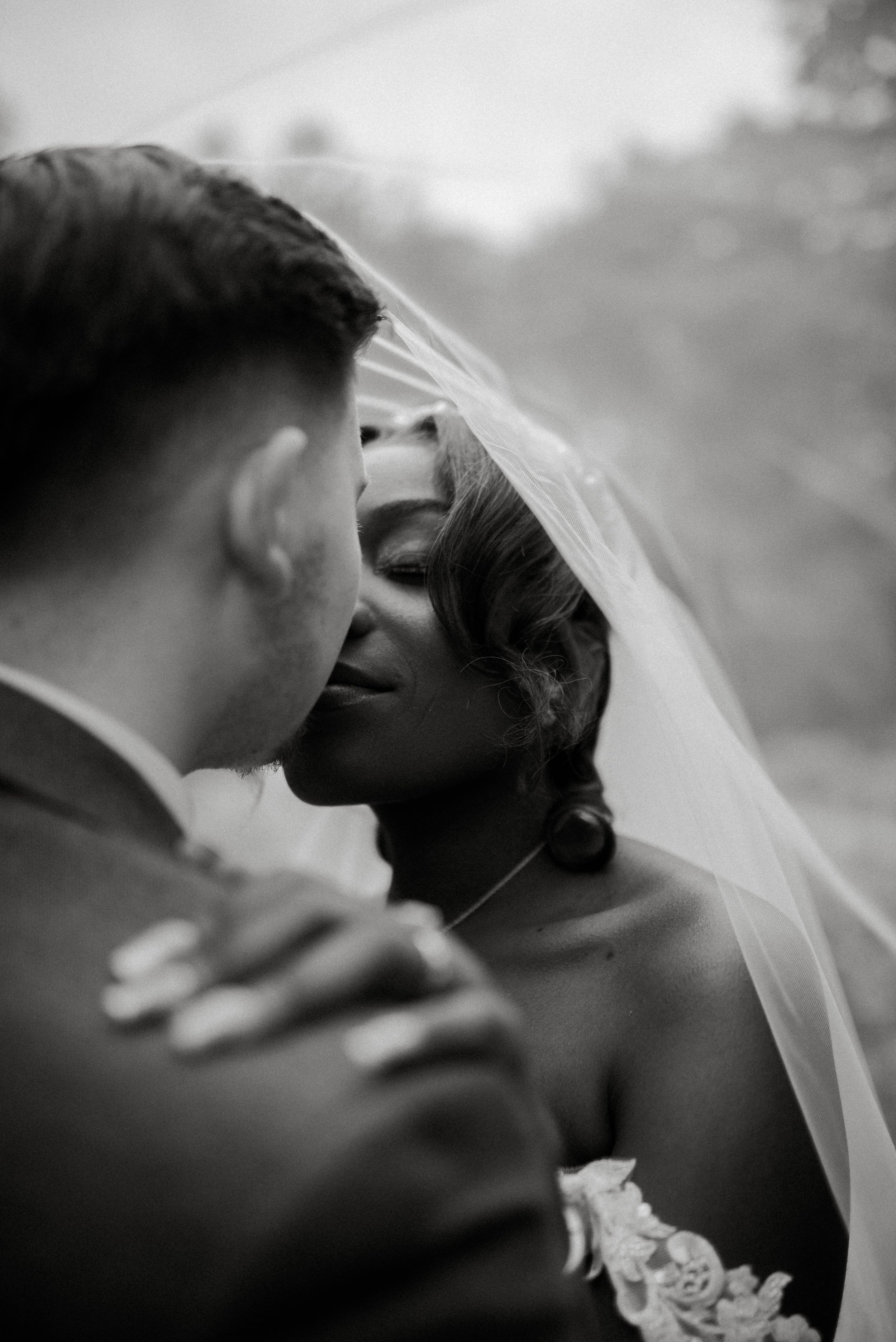 Black and white wedding portraits capture tender moments between newlyweds.