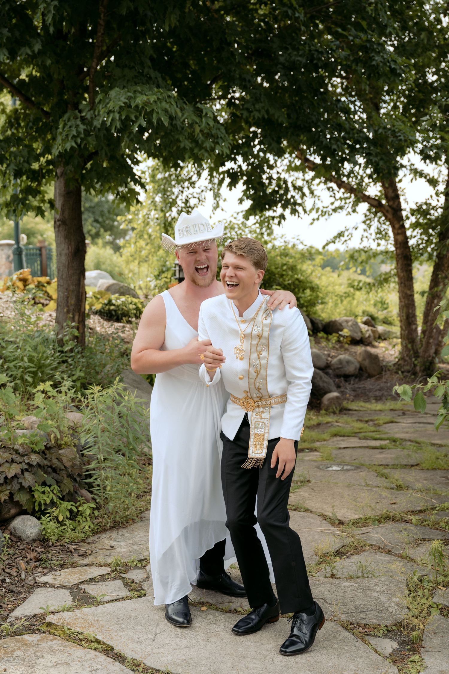 Silly photo of a groomsmen dressing up in a bridal dress for a fake first look with the groom at the Millenium Gardens in Plymouth, MN.