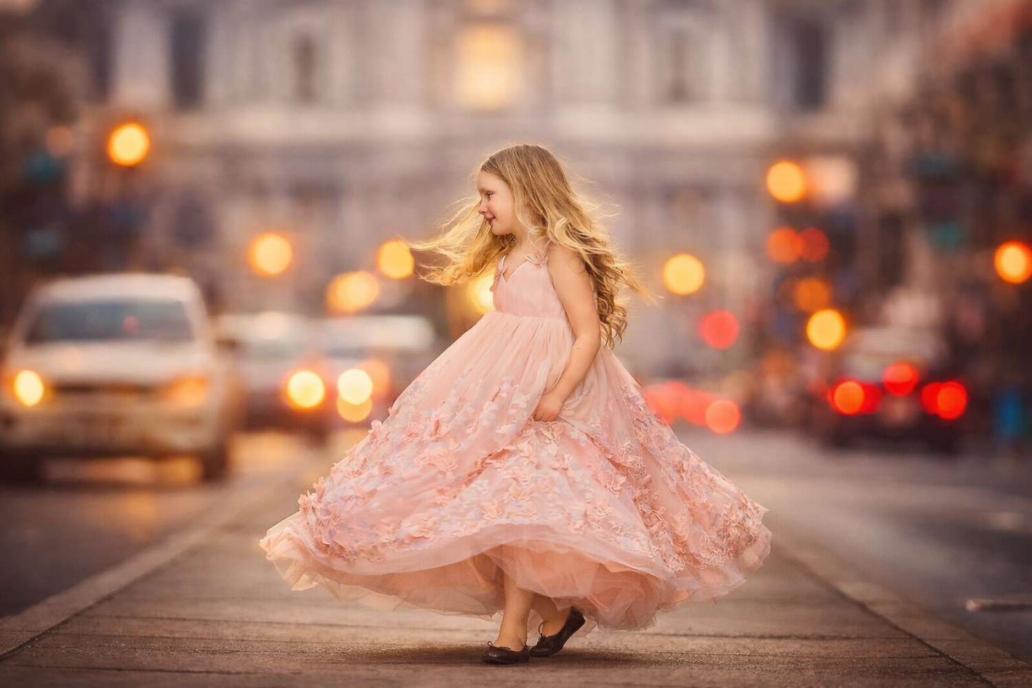 Girl in pink dress twirling on the street in Philadelphia