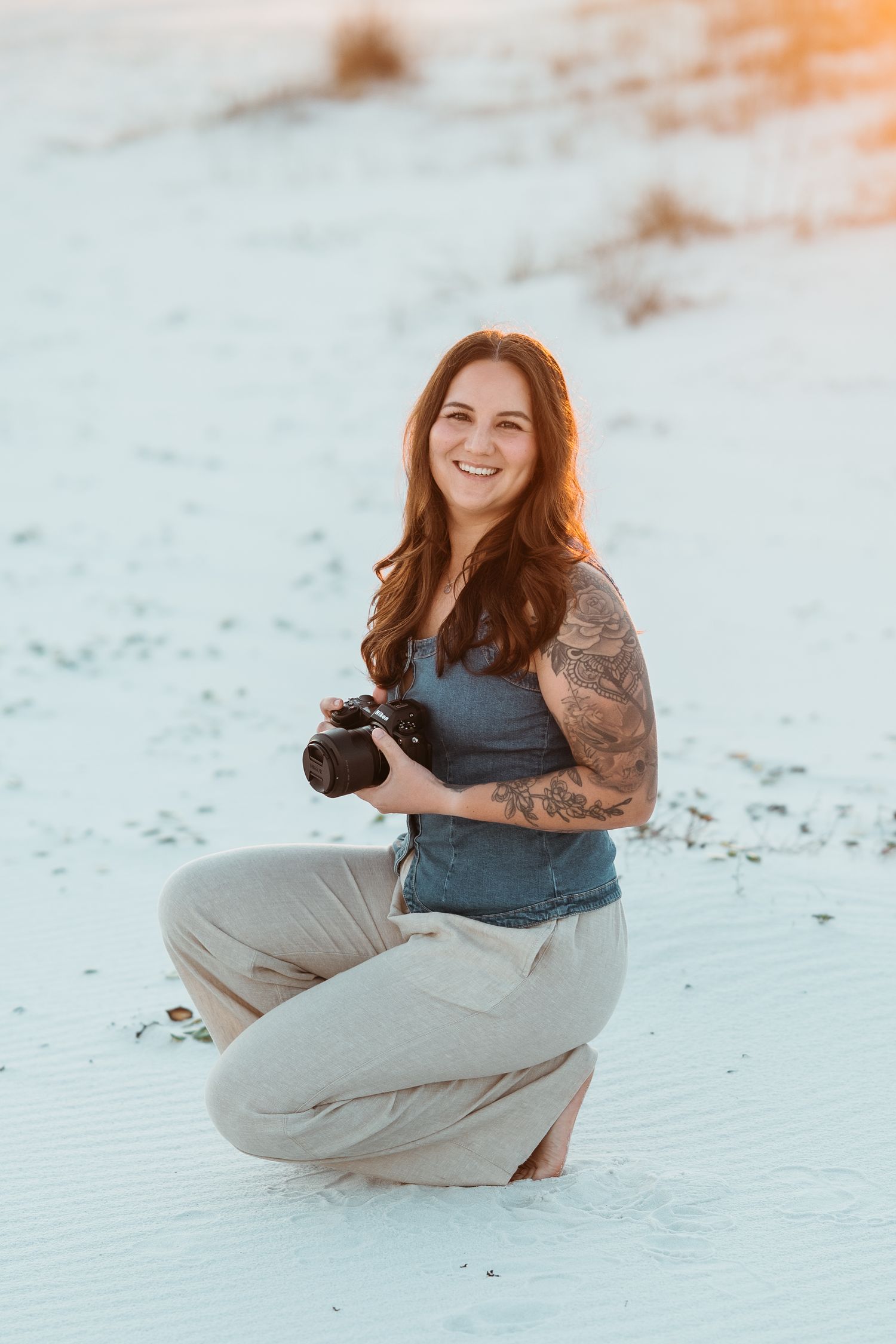 Megan Lee, Pensacola family and couples photographer, holding her camera on the beach