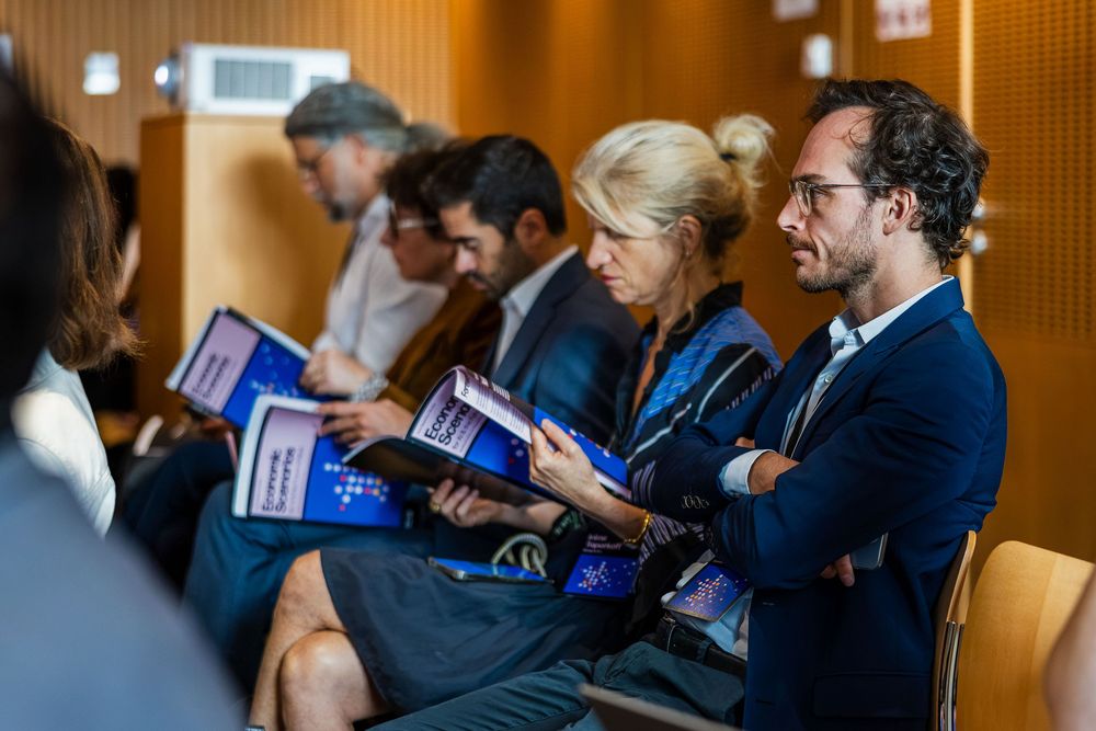 Participants reviewing scenario booklets at Windfall Trust AI workshop, Collège de France, Paris - parisianphotographers.com