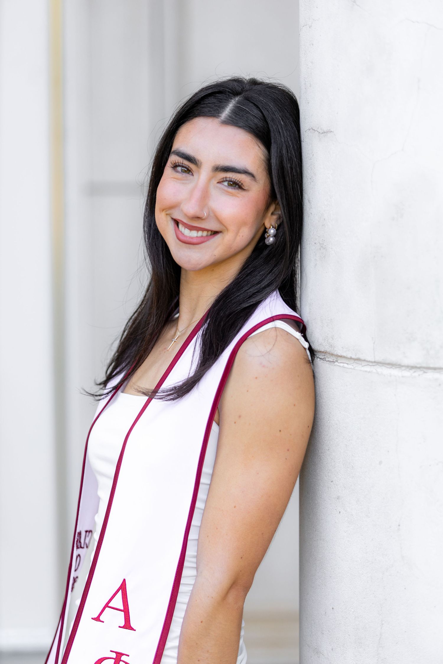 College graduate smiling in her graduation stole for a senior portrait
