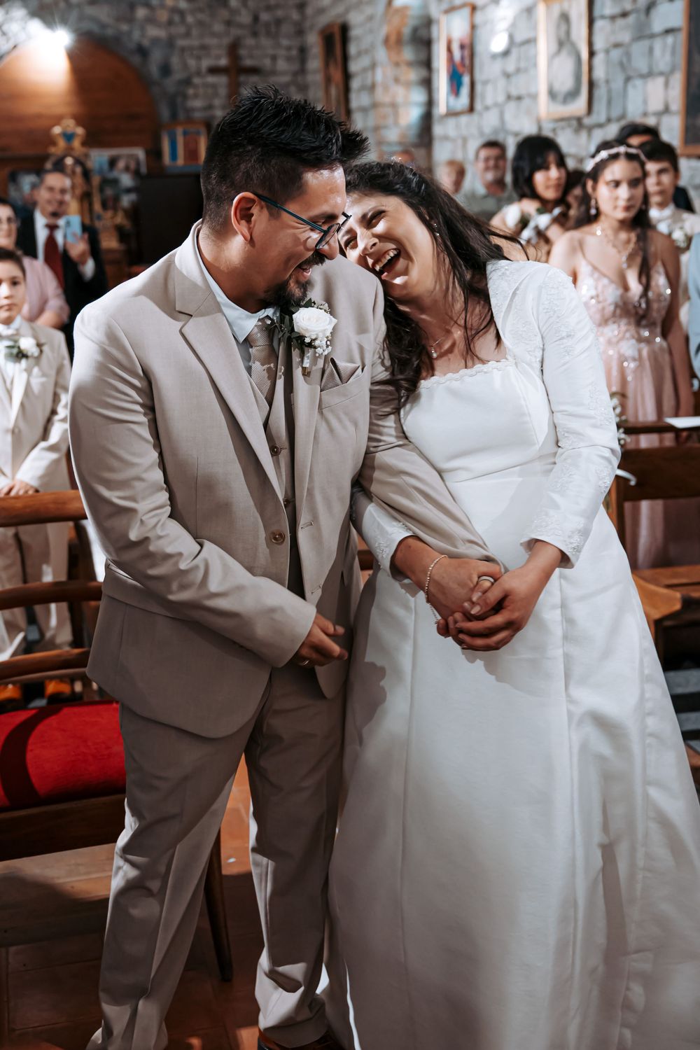 Joyful bride and groom laughing together at the altar during their church wedding ceremony.