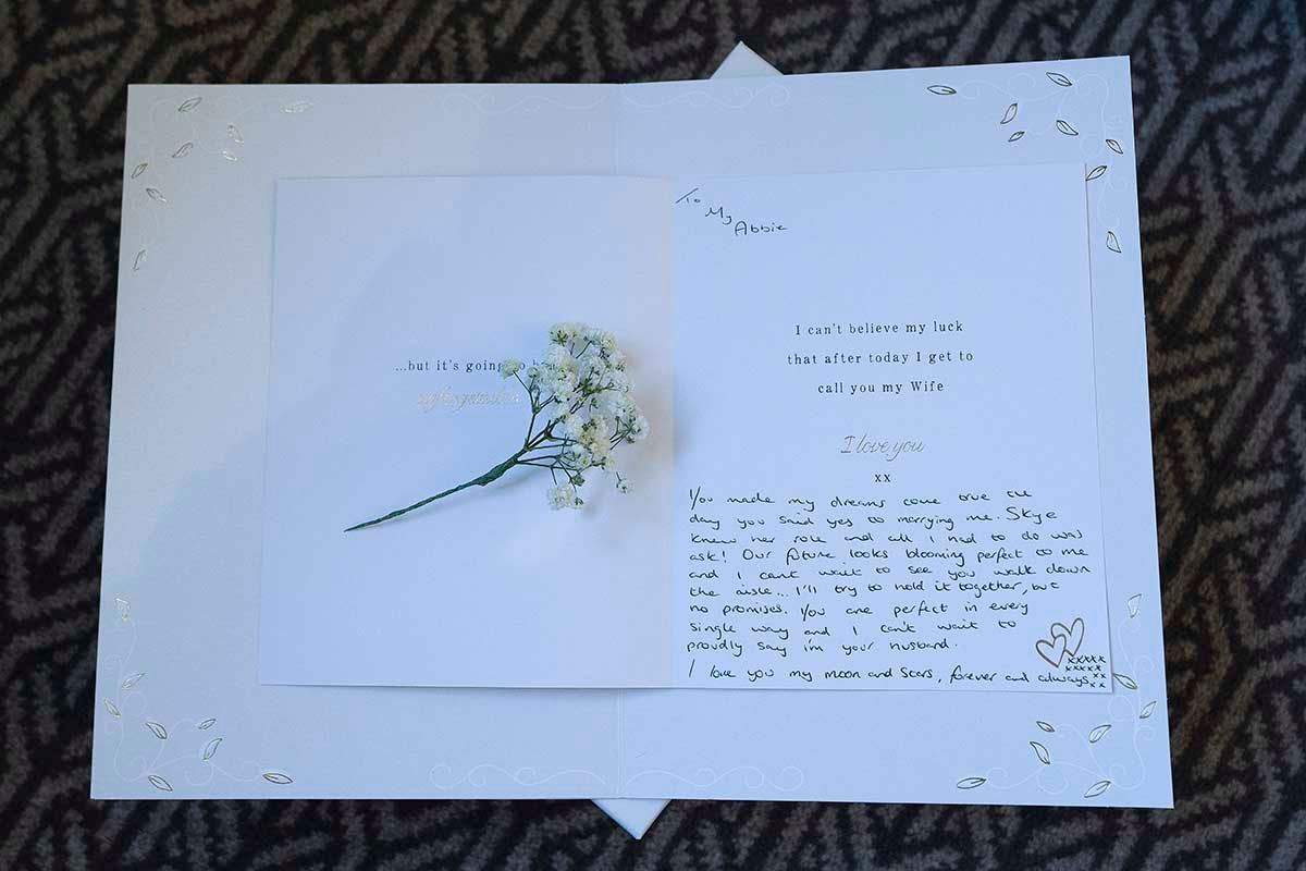 Handwritten love letter with dried white baby's breath flowers on a white card with elegant script give to Abbie in the morning