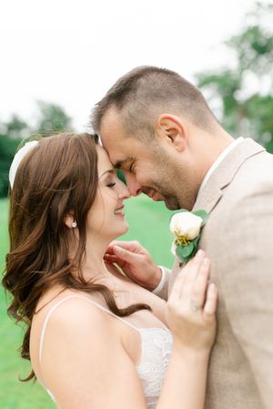 Romantic close-up of bride and groom touching foreheads tenderly on their wedding day.