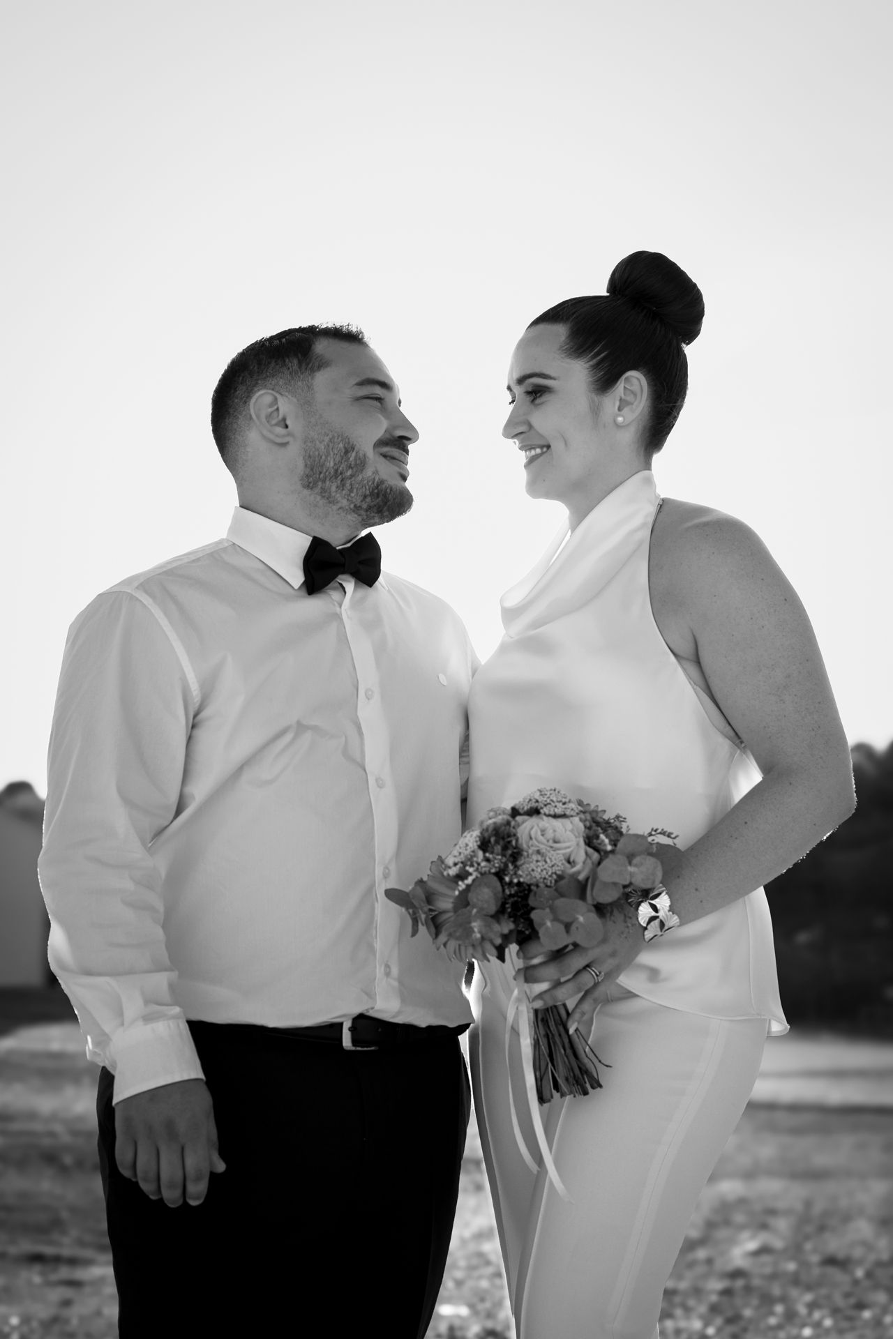 Mariés en noir et blanc côte à côte, nœud papillon et bouquet à la main, mariage civil à Lyon