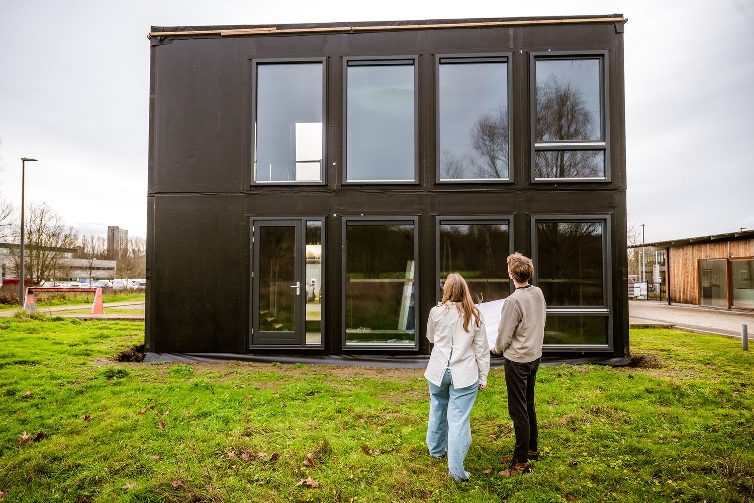 Twee professionals bekijken de bouwplannen bij een modulair bouwproject in België.