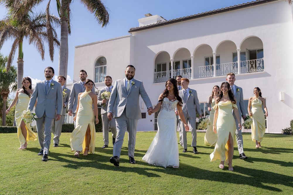 Bride and groom walking with their wedding party across the lawn at The Mansion at Tuckahoe in Jensen Beach, FL