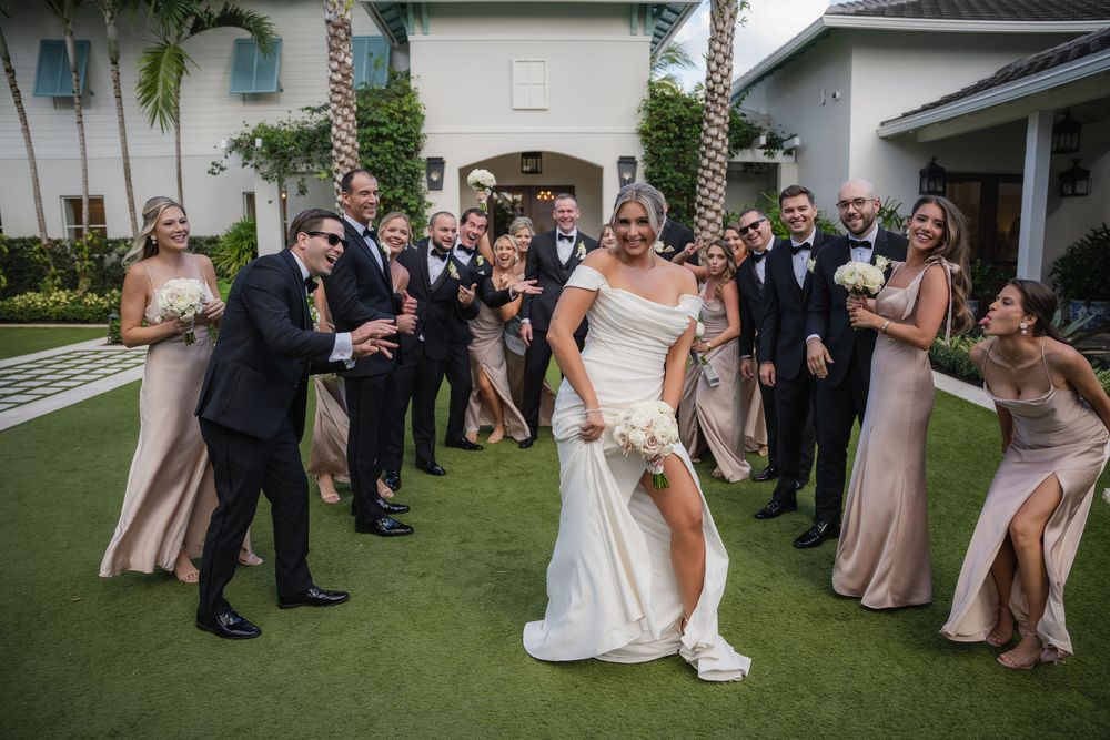 Bride laughing as her wedding party gathers around her at Pelican Club in Jupiter, FL