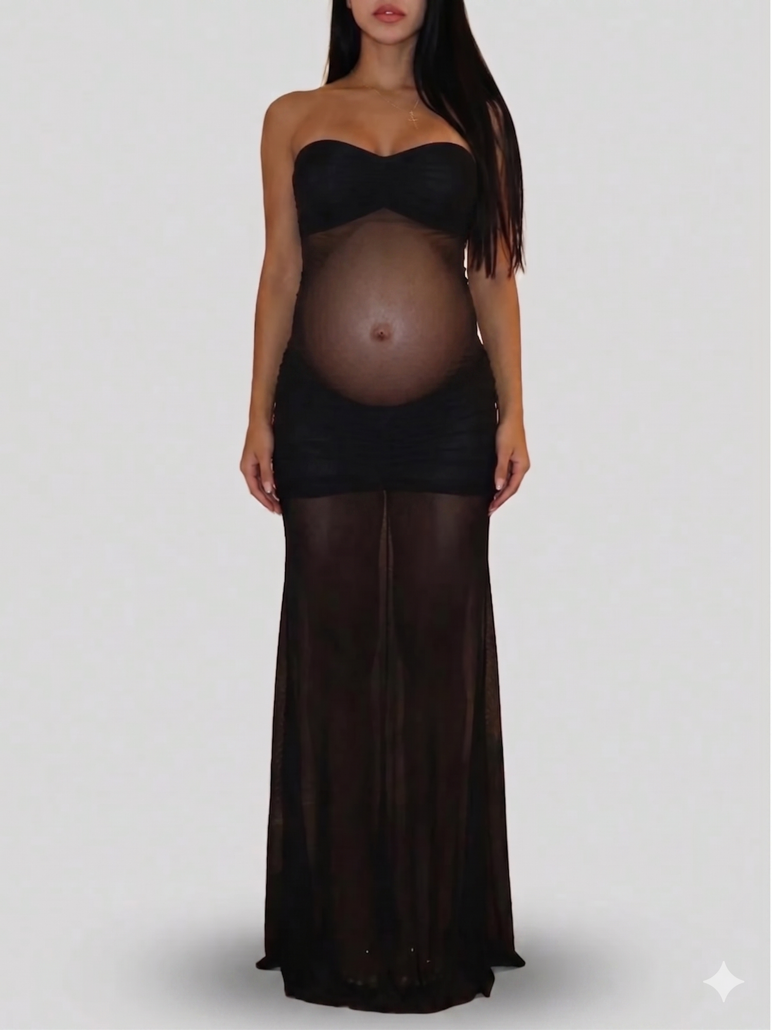 Black strapless sheer maxi maternity dress with sweetheart neckline, showcasing baby bump through mesh fabric.