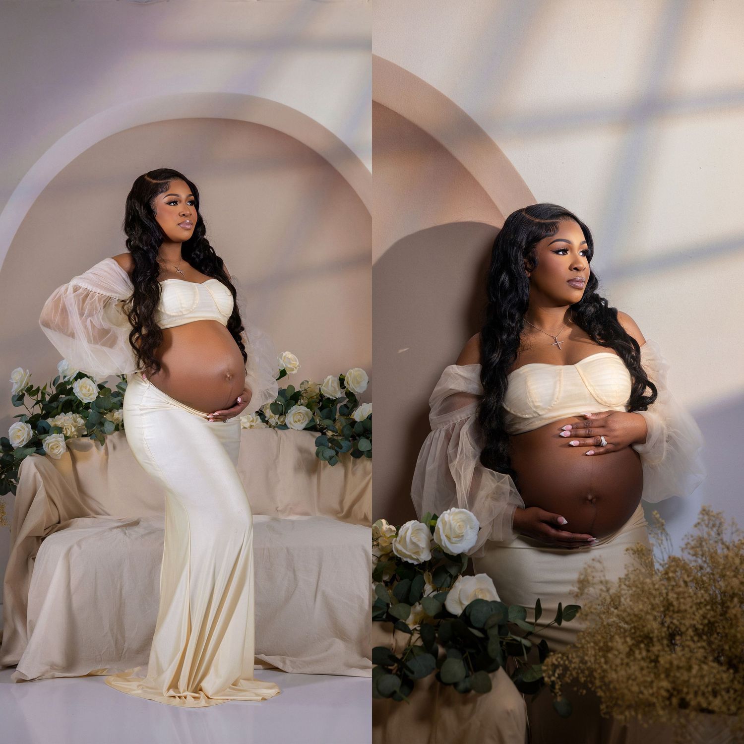 Pregnant woman in elegant white maternity gown with sheer sleeves poses for professional studio photography session.