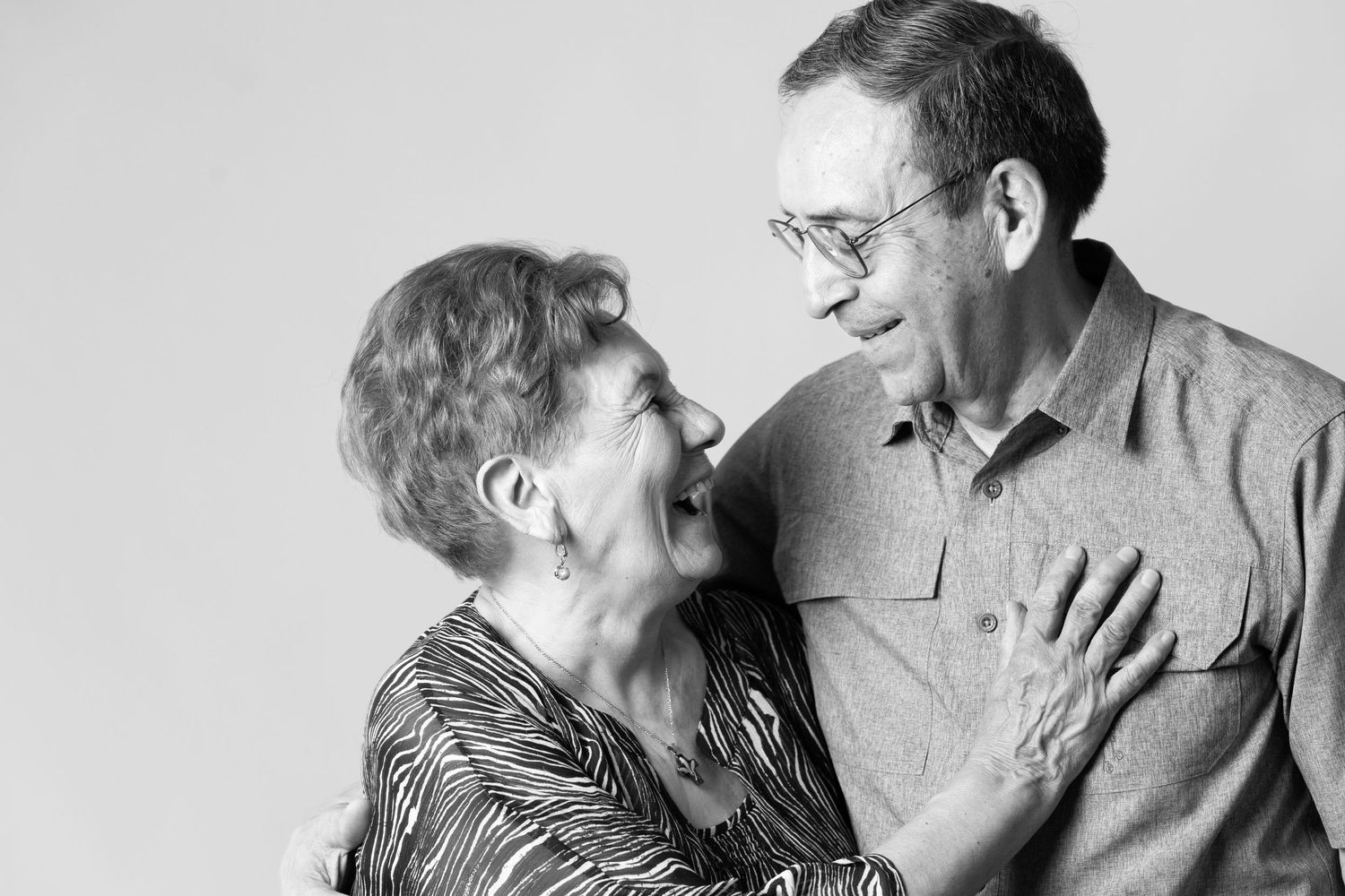 Black and white portrait of an elderly couple sharing an intimate moment.
