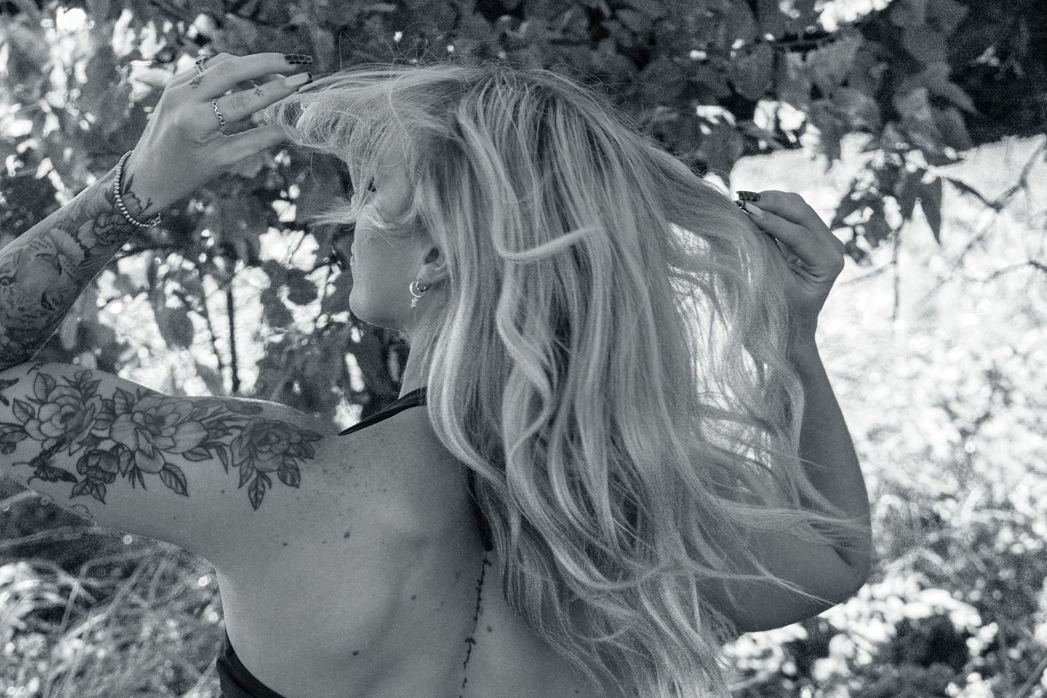 Black and white outdoor portrait of a woman surrounded by trees during a creative portrait session.