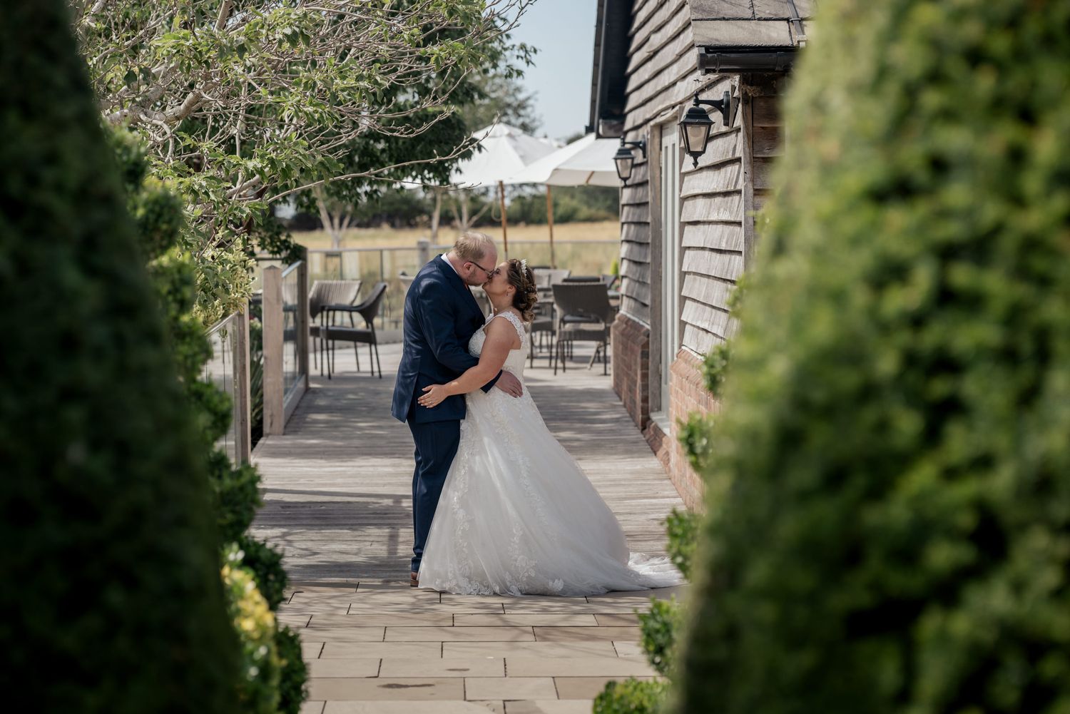 Bride and groom pose between two iconic red British telephone boxes on their wedding day.