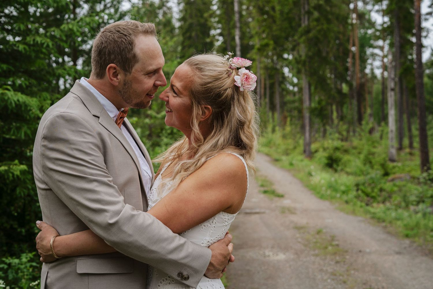 Brudpar ser kärleksfullt på varandra under sin bröllopsfotografering i Ockelbo