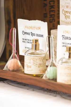 Elegant Compass Rose cologne bottle displayed on wooden tray with Florida lavender soap and decorative glass funnels.