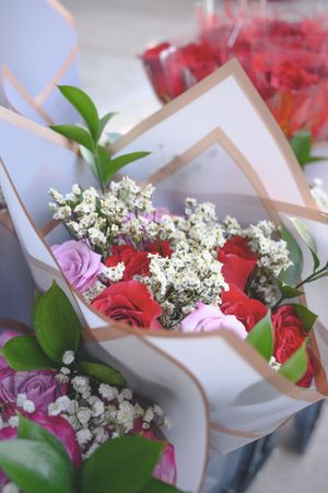 Beautiful bouquet of red and pink roses with white baby's breath, wrapped in kraft paper, perfect for Valentine's Day.