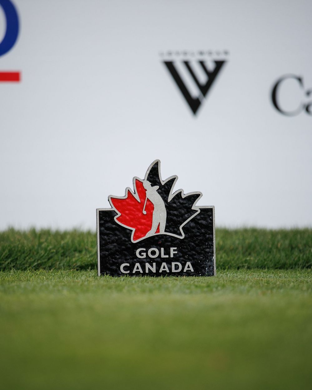 Golf Canada logo marker on green grass at a golf tournament.