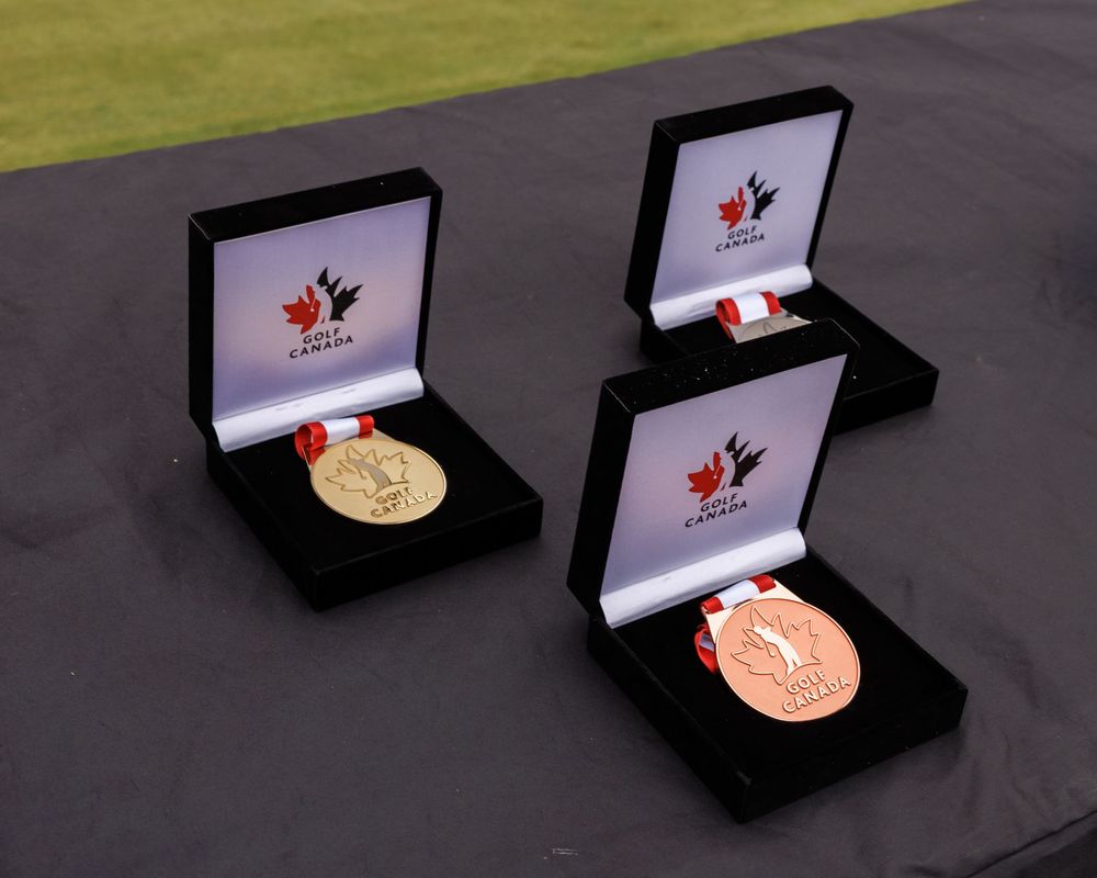 Three Golf Canada championship medals displayed in black velvet presentation boxes.