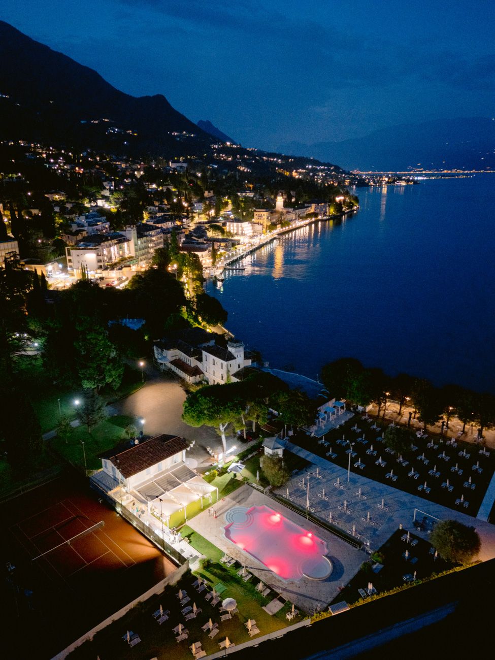 Aerial shot by night of a beach club at Lake Garda for a laid-back welcome party on the shores of the lake. Planned by Solidea Events