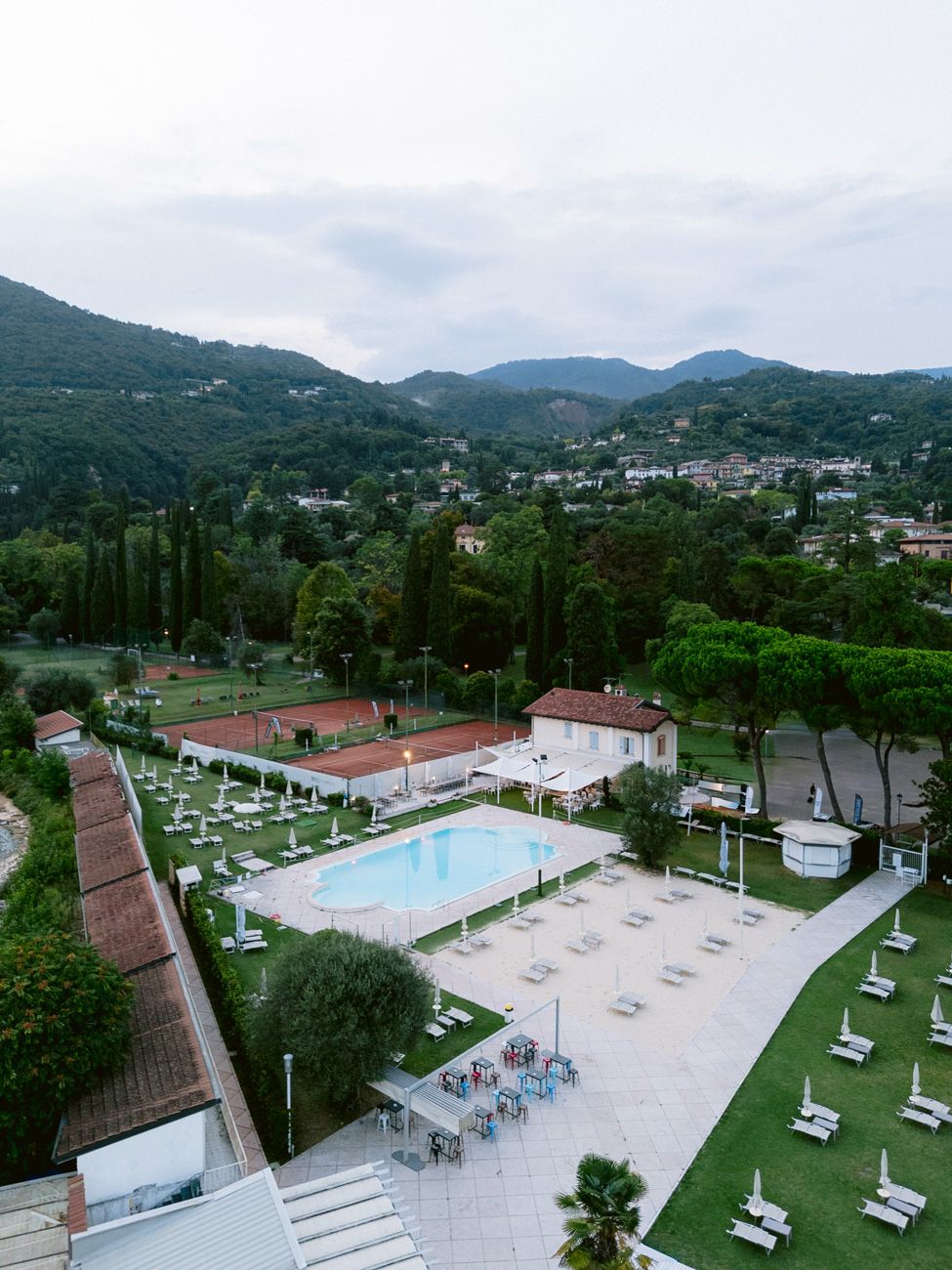 Aerial shot of a beach club at Lake Garda for the first day of celebrations of a three-day destination wedding on the shores of the lake.