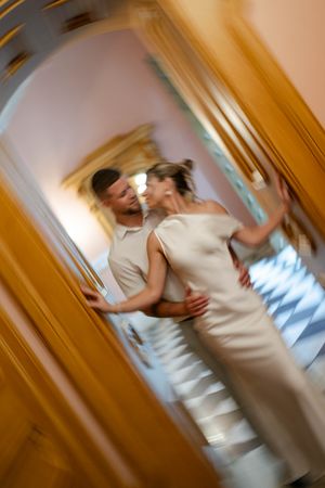 Dreamy blurred motion shot of a couple embracing in an ornate golden doorway during their wedding day.