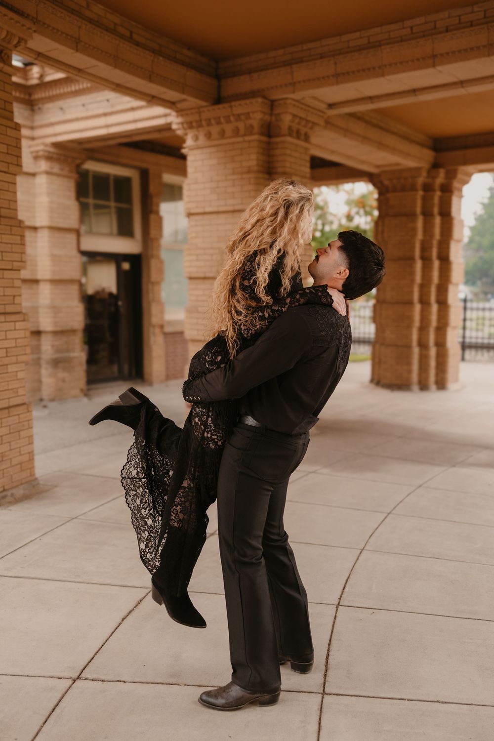 Couple kisses under the historic train station in Livingston, Montana captured by local Paradise Valley Wedding Photographer