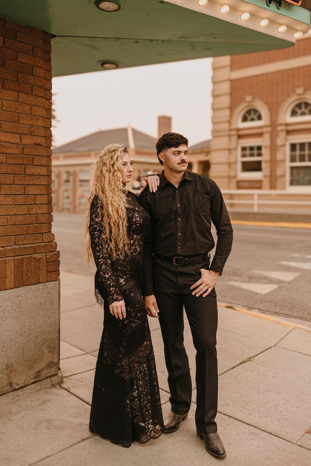 Couple poses under the Murray Hotel Neon light signs in Livingston, Montana for their welcome party pre-wedding - Paradise Valley Wedding
