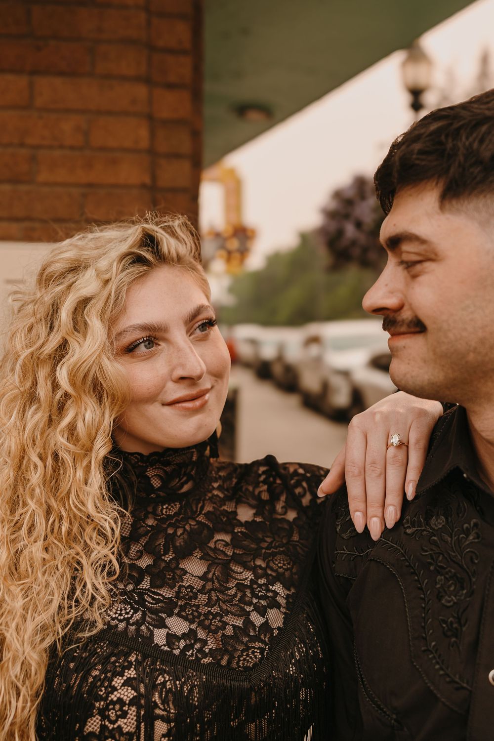 Couple poses under the Murray Hotel Neon light signs in Livingston, Montana for their welcome party pre-wedding - Livingston Welcome Party