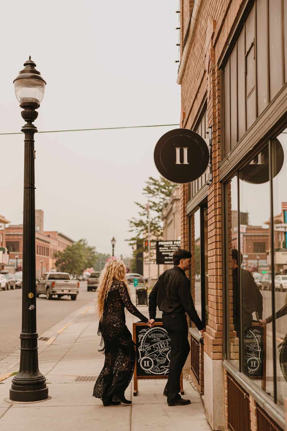 Couple walks into 2nd Street Bistro Livingston, Montana as they start their Welcome Party the night before their wedding -Local Photographer