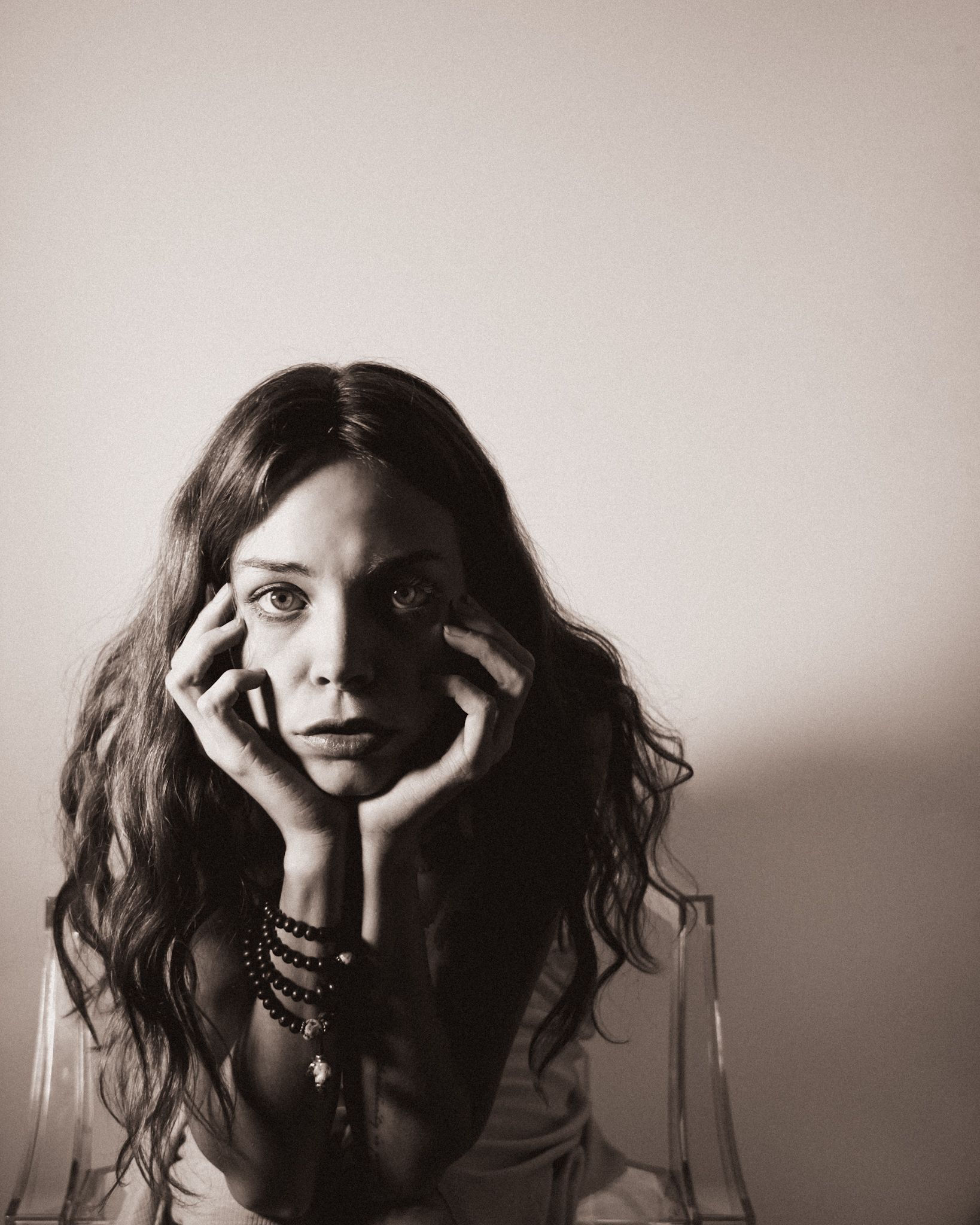 Danimari Anzi, founder of Alchemy of Hearts, sitting in a clear chair during a self portraiture taken in the studio.