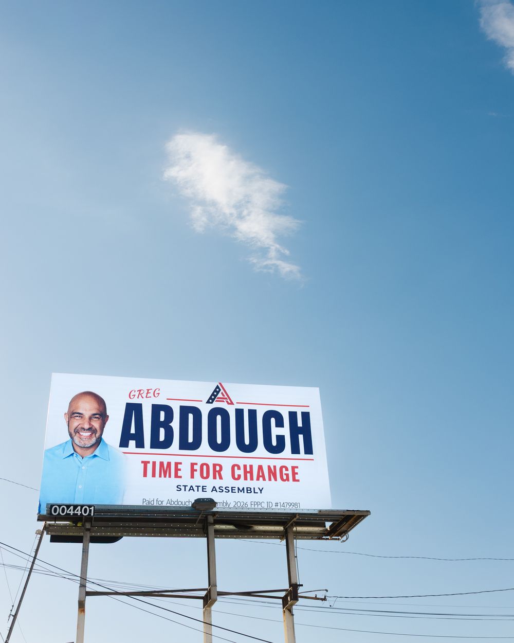 Billboard for Greg Abdouch's State Assembly campaign with the slogan Time for Change, set against a bright blue sky with a wispy cloud.
