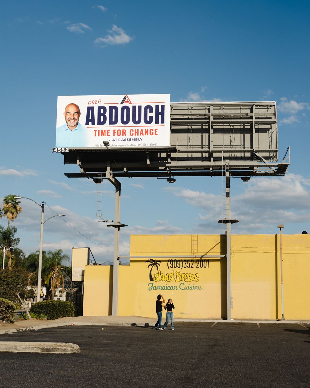 Abdouch State Assembly Time for Change billboard stands above a yellow restaurant.