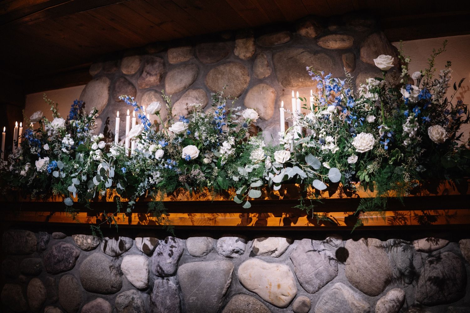 Candlelit Fleurish greenery along the stone wall of the Post Hotel banquet hall, Lake Louise