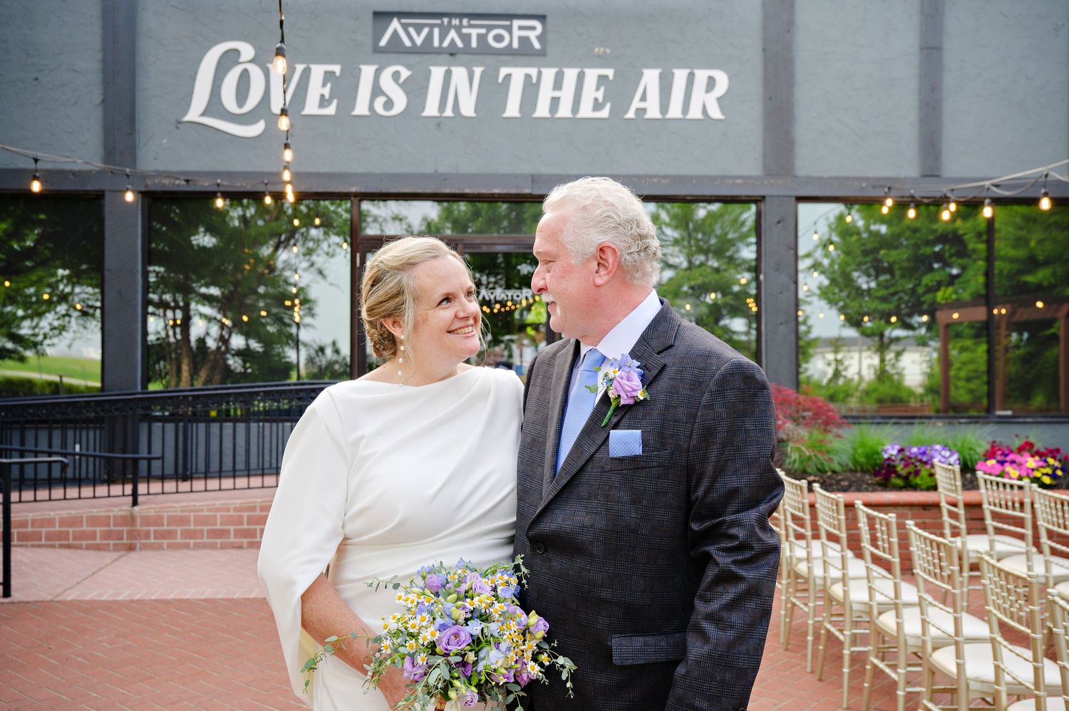 Bride and groom smiling at each other after their wedding ceremony outside at The Aviator in Cleveland Ohio in June.