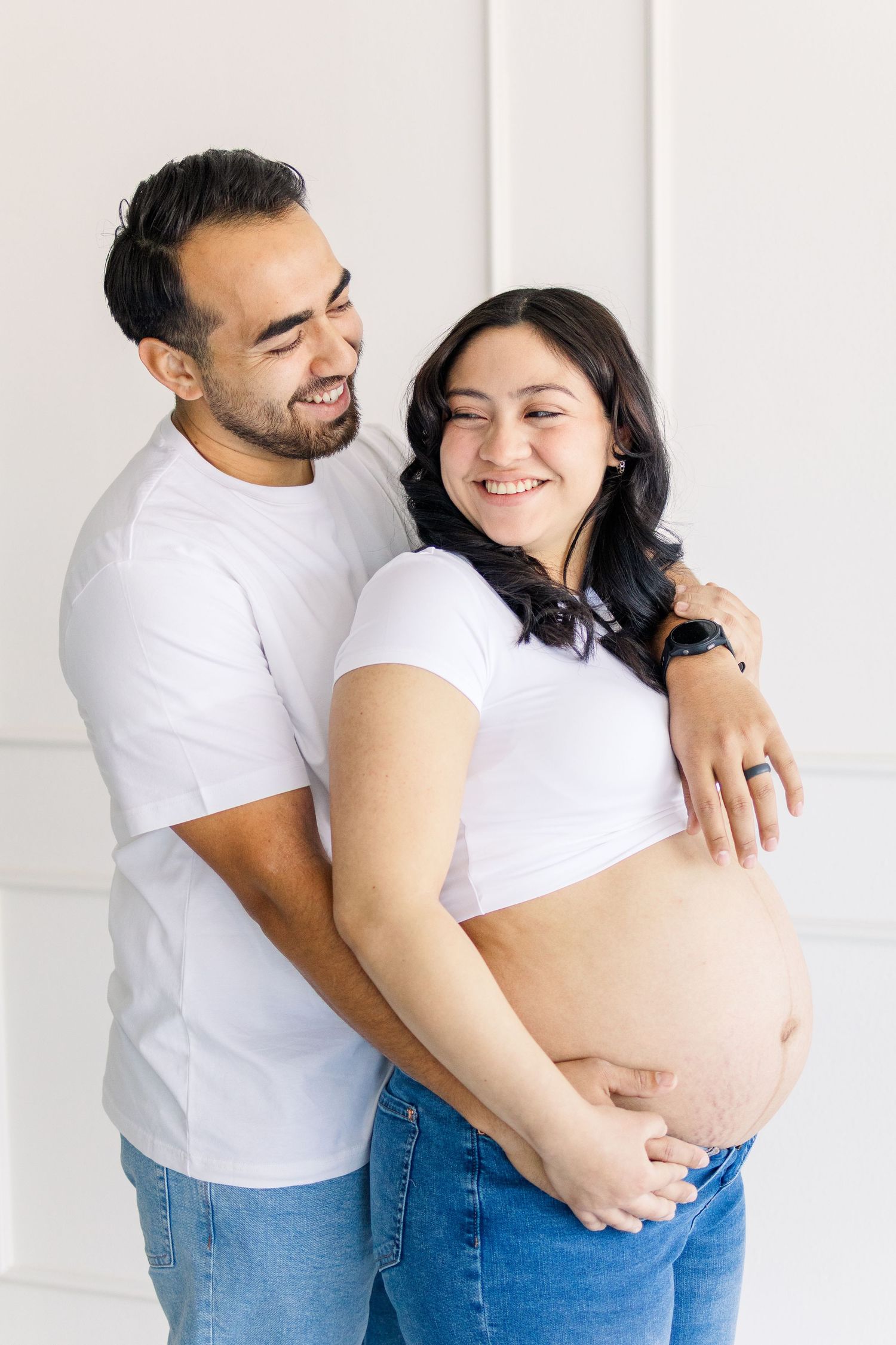 Young mom and dad light and airy maternity studio session, smiling together in Mesa, Arizona.