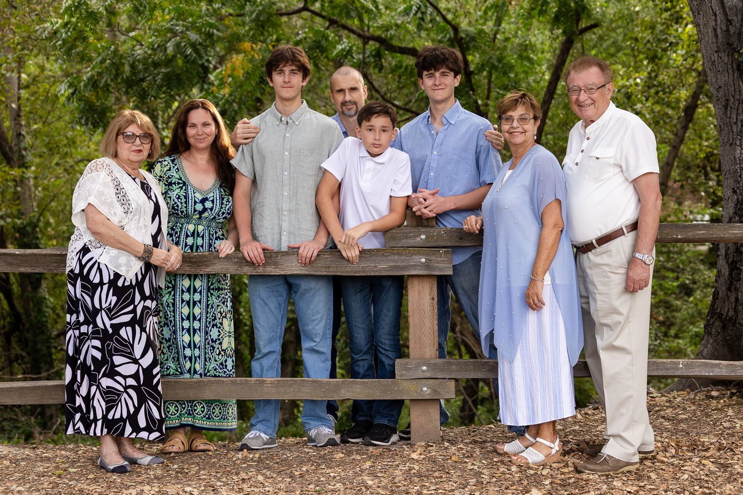 An extended family session in front of a wooden fence in Los Gatos