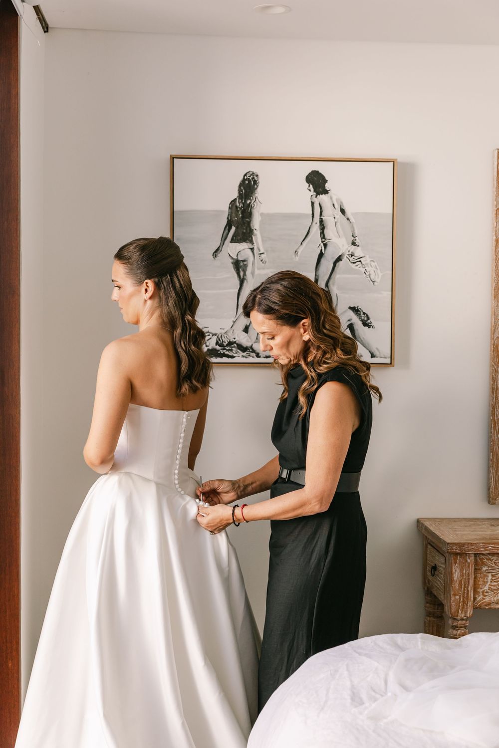 Bride having her wedding dress fastened while getting ready before her Byron Bay wedding ceremony.