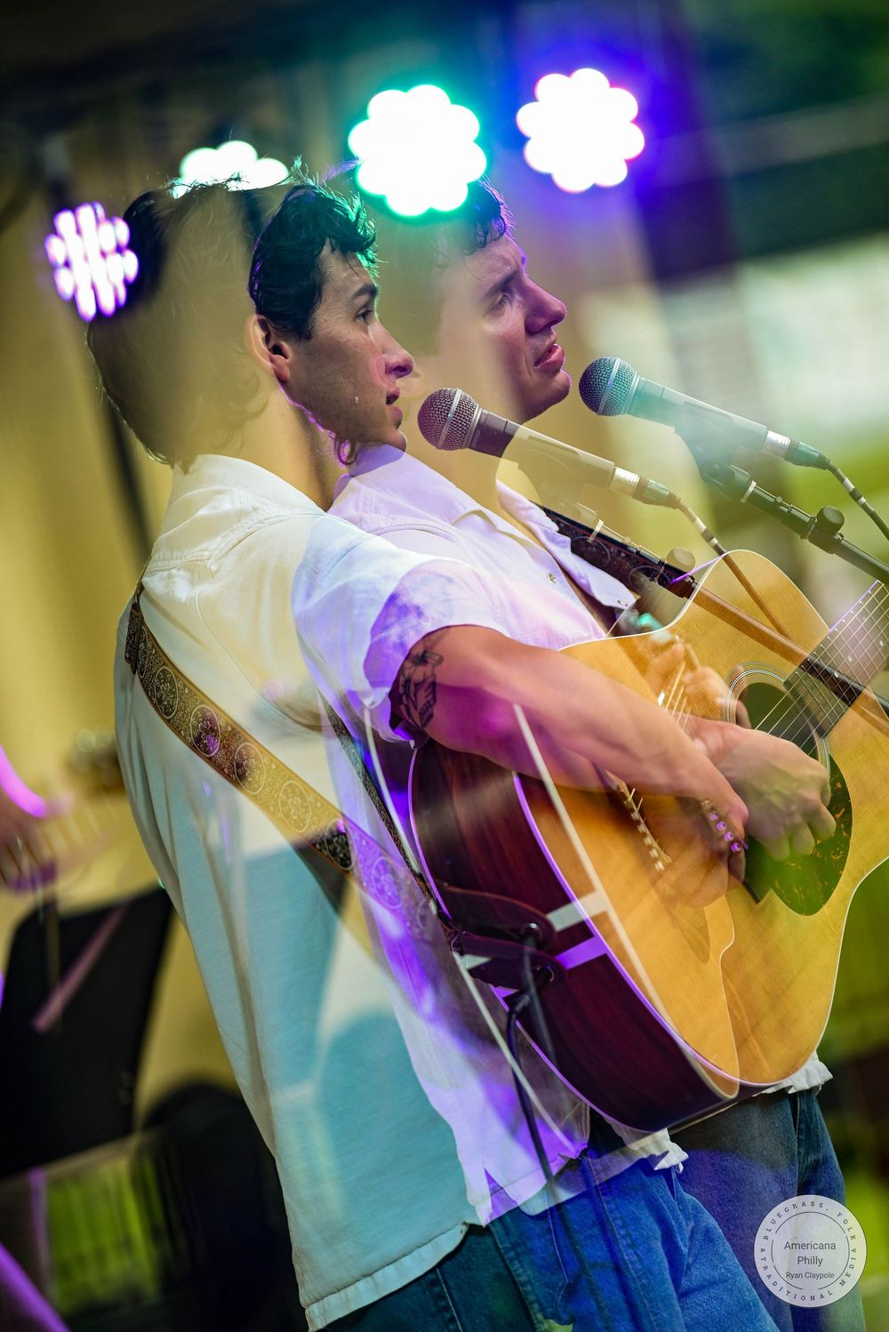 Young man playing acoustic guitar on stage with colorful lights, captured in a double exposure effect.