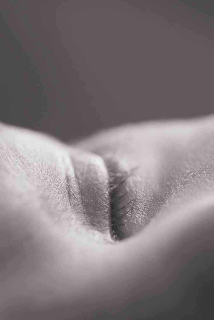 Close-up black and white macro photo of human skin texture showing a natural fold or crease in soft focus.