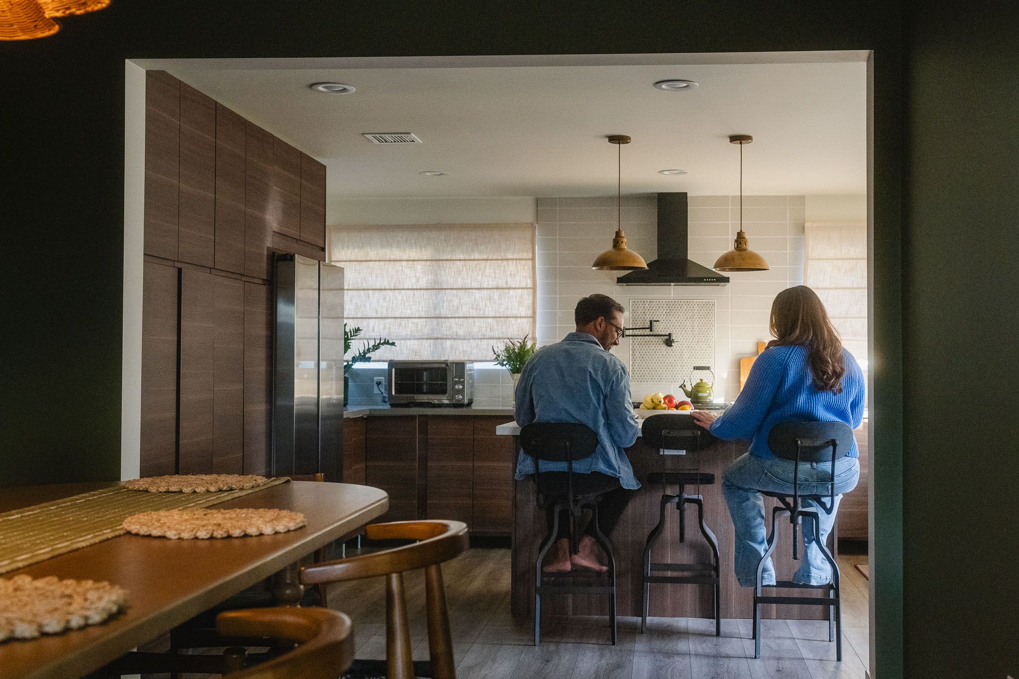 Amanda and Rohan photographed from behind in their kitchen during a natural maternity shoot