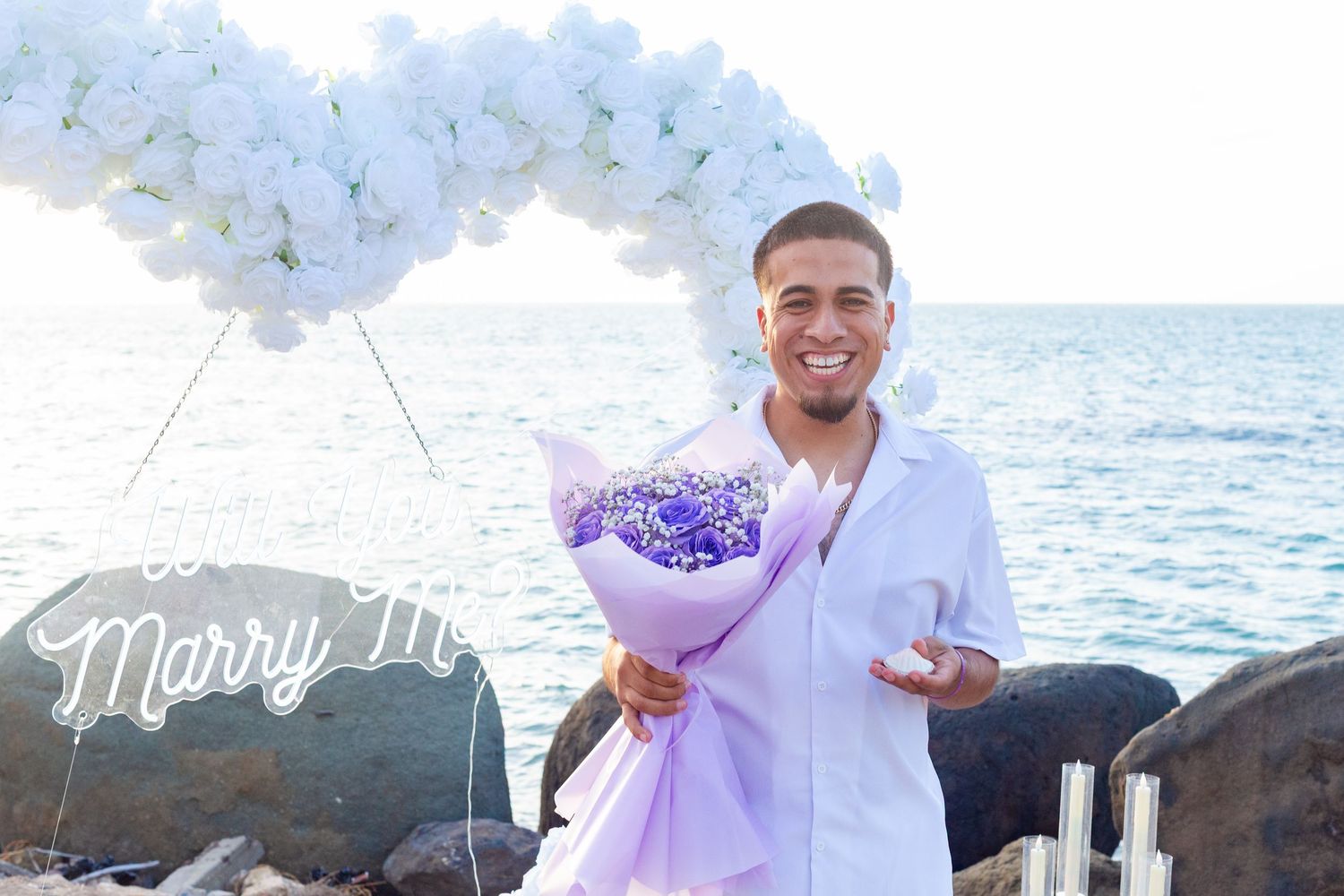 Marriage proposal. Man waiting for the woman. Decorative setup with white flower heart overlooking the ocean in Río Grande, Puerto Rico.